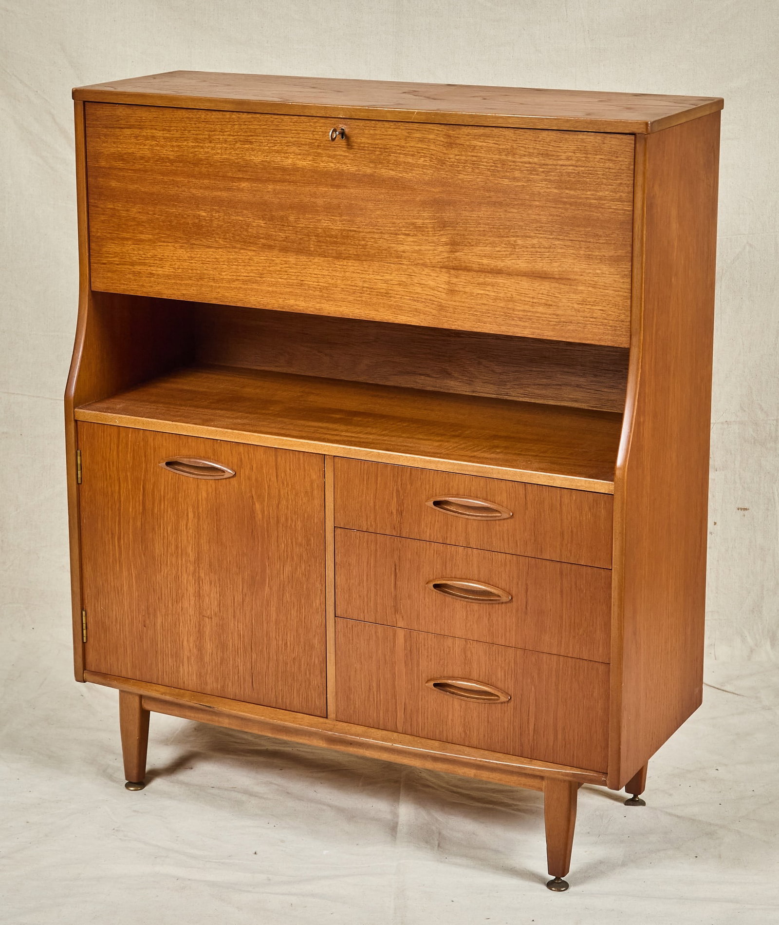 MID-CENTURY JENTIQUE TEAK SECRETARY: Upper section with fall front fitted with drawers & shelves, middle shelf, lower section with single cabinet & (3) drawers. Unmarked. 43 x 36 1/4 x 14 inches.