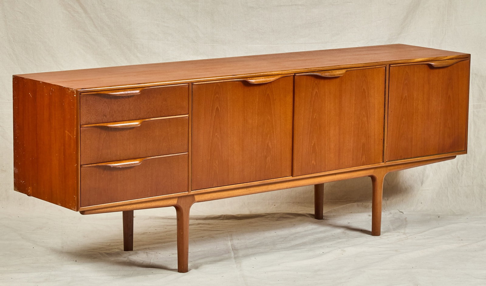 MID-CENTURY A.H. MCINTOSH CREDENZA: Central (2) door cabinet with inner shelving flanked by (3) graduated drawers and a fall front cabinet with hidden slide-out tray, nice molded pulls. 29 1/2 x 79 1/4 x 18 1/2 inches.