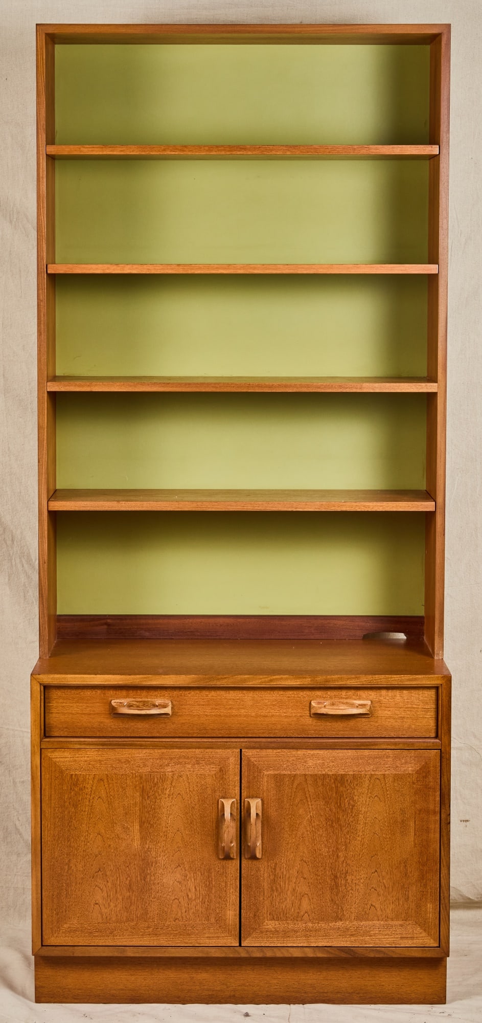 G PLAN MID-CENTURY TEAK "SIERRA" WALL UNIT: Upper case with (4) shelves and painted back, lower case with (2) drawers and a lower cabinet with beveled drawers and carved pulls. 78 x 33 x 19 inches.