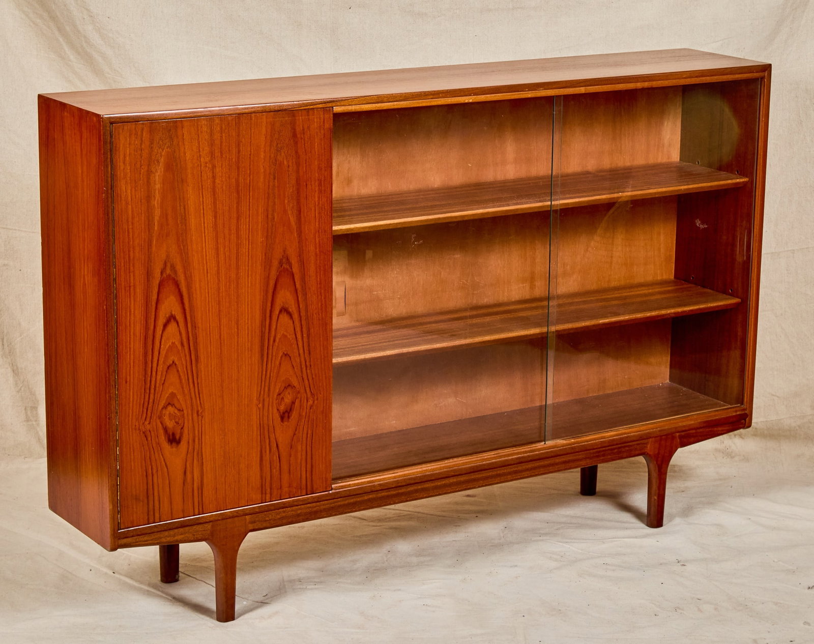 A.H. MCINTOSH MID-CENTURY TEAK BOOKCASE: With sliding glass doors. 34 3/4 x 53 1/2 x 10 inches.