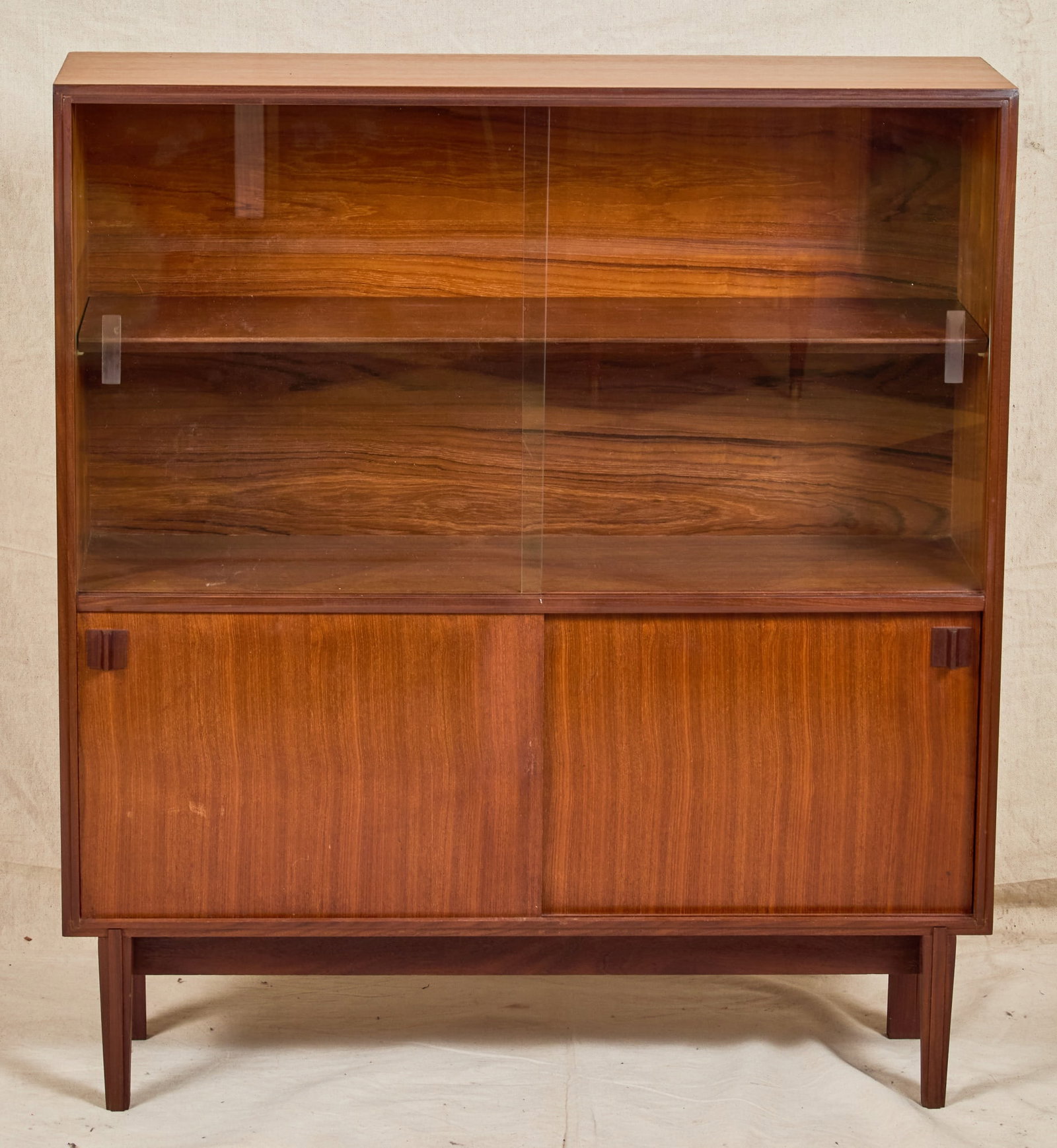 BEAVER & TAPLEY MID-CENTURY COCKTAIL CABINET: Upper section with (2) sliding glass doors and single shelf, lower section with (2) sliding wooden doors, on carved feet. 40 x 36 x 10 1/2 inches.