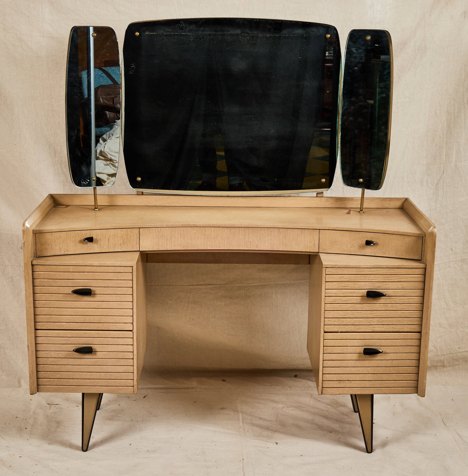 HARRIS LEBUS PAINTED MID-CENTURY LINK RANGE VANITY: With nice frameless triptych mirror, convex upper case with (3) drawers including central fitted with jewelry tray, (2) two drawer banks with shutter fronts and nice mid century pulls, raised on
