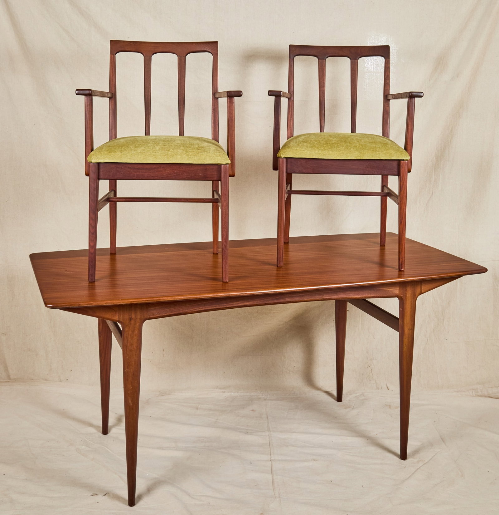 A YOUNGER 'VOLNAY' AFROMOSIA DINING TABLE & CHAIRS: Mid century dining room set designed by John Herbert for A. Younger "Volnay" series constructed from rich afromosia wood, dining table and (2) armchairs with avocado upholstered seats. 29 1/2 x 32 x