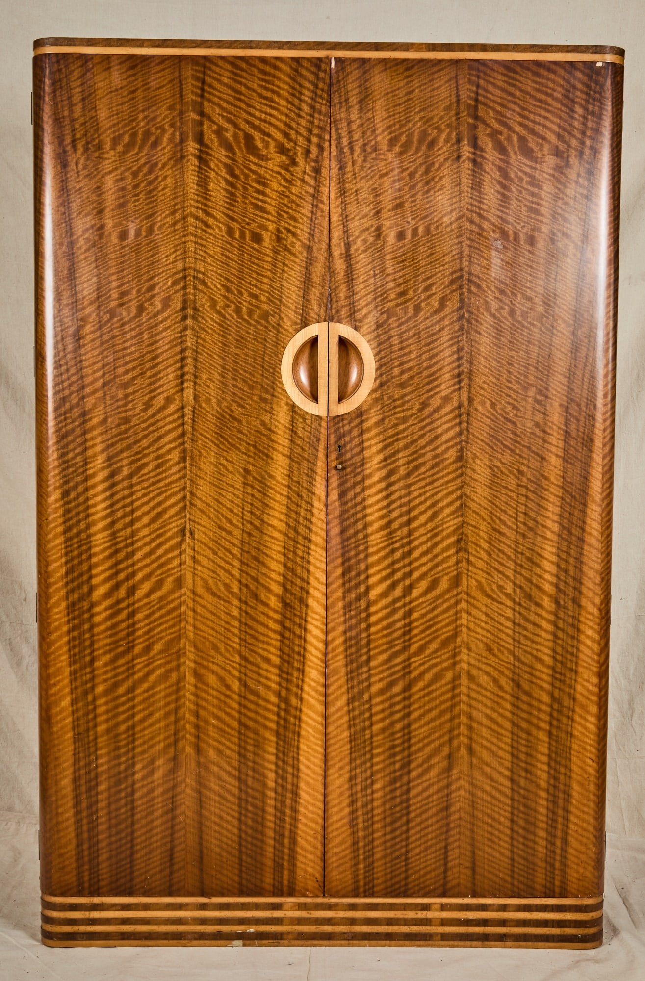 ART DECO ARMOIRE by SALOMON HILLE of LONDON: Pair of book-matched tiger-grained contrasting wood doors opens to a (2) compartments fitted with coat rack, hooks, shelves, (2) glass front drawers, and a full-length mirror. 73 x 46 x 20 inches.