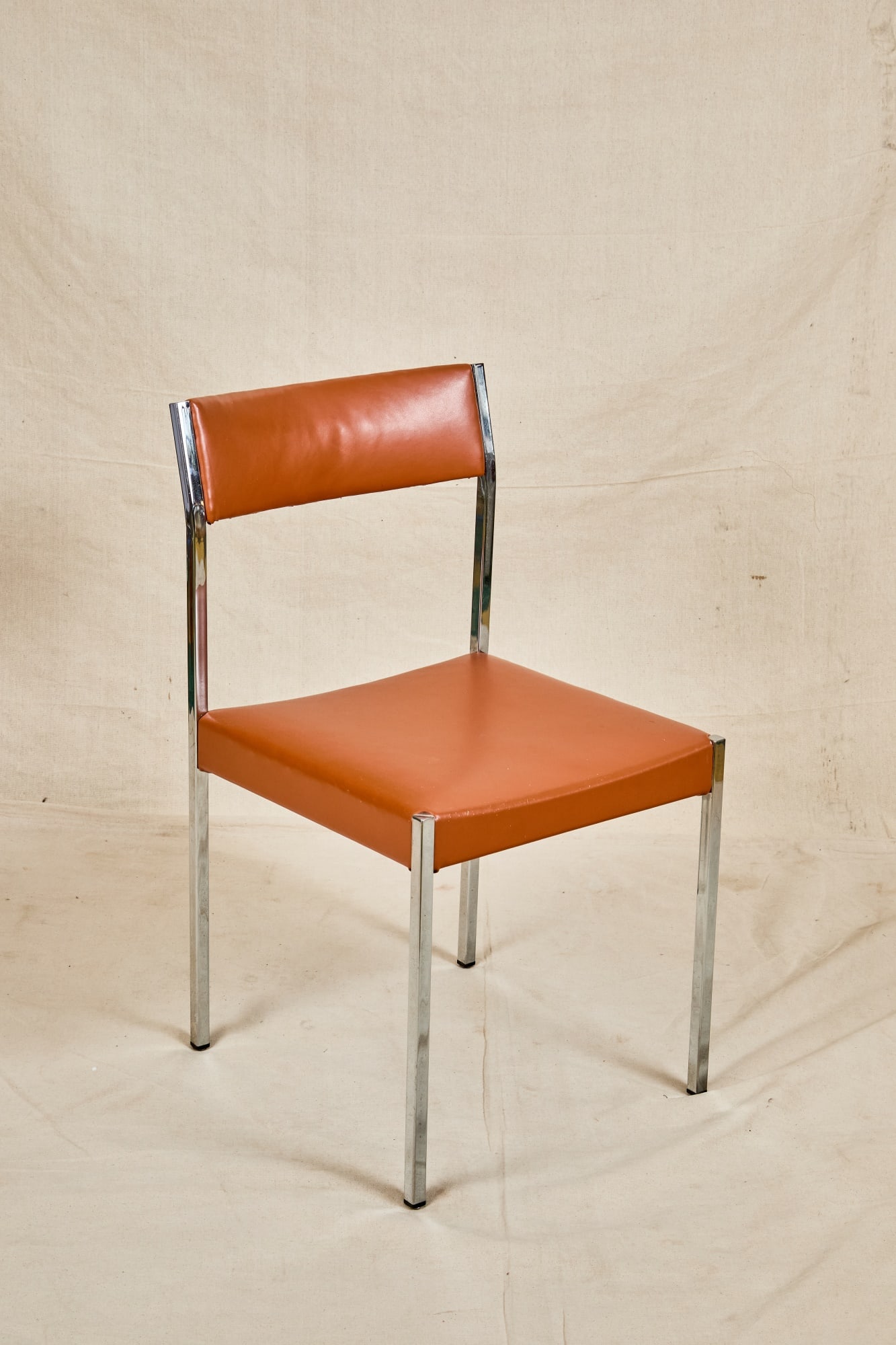 MID-CENTURY CHROME & VINYL SIDE CHAIR: Chrome frame with burnt orange vinyl upholstery. 31 x 17 x 17 inches.