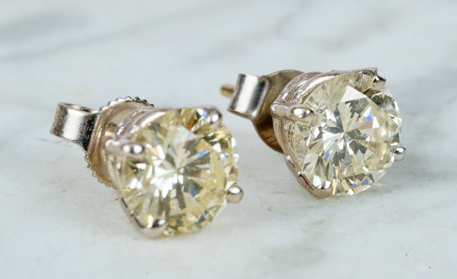 PAIR of DIAMOND STUD EARRINGS: Set in 14k white gold. In original Bloomingdale's box. Each diamond measures approx. 6.4 mm and shows some faint color. 1 dwt gross weight. 2ct TWT.