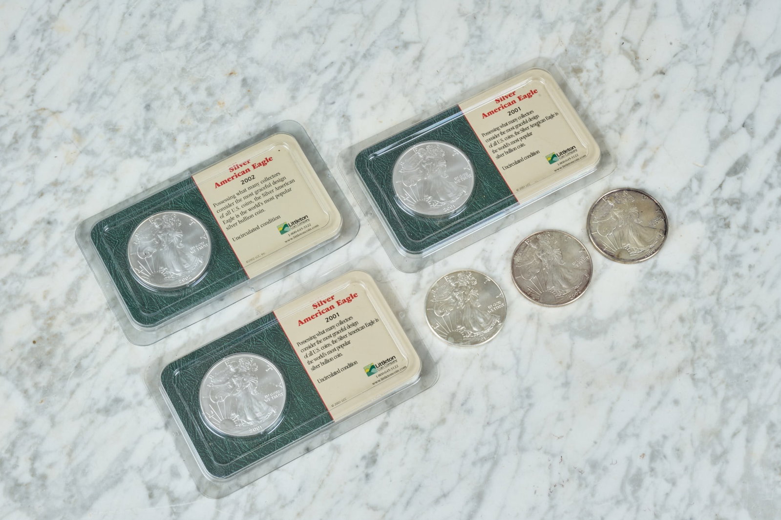 (6) SILVER AMERICAN EAGLE DOLLARS: (1). ozt fine silver each. (2) 2001, (2) 2002, (1) 2006, & (1) 2012. Uncirculated. 1 1/2 inches.