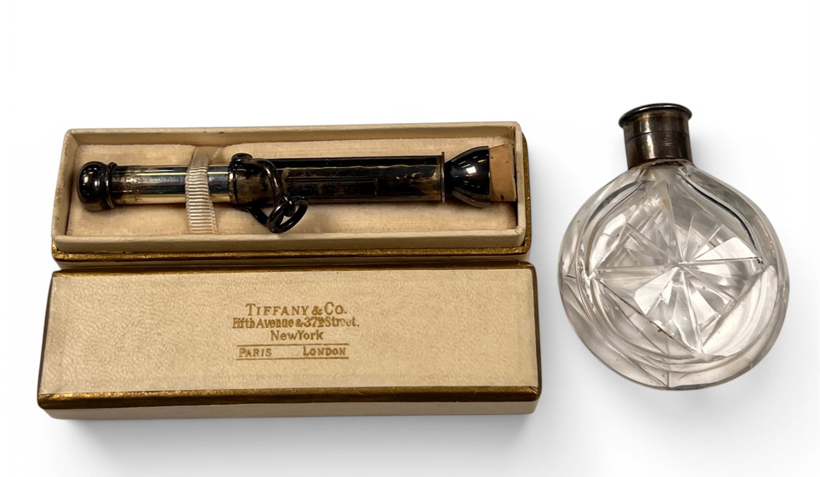 TIFFANY & CO STERLING SILVER CIGAR PUNCH: Marked Tiffany & Co Sterling. Monogrammed EJC. Presented in the original box. Along with a cut glass perfume with sterling silver top. Punch .47 OZT Condition: Wear from use