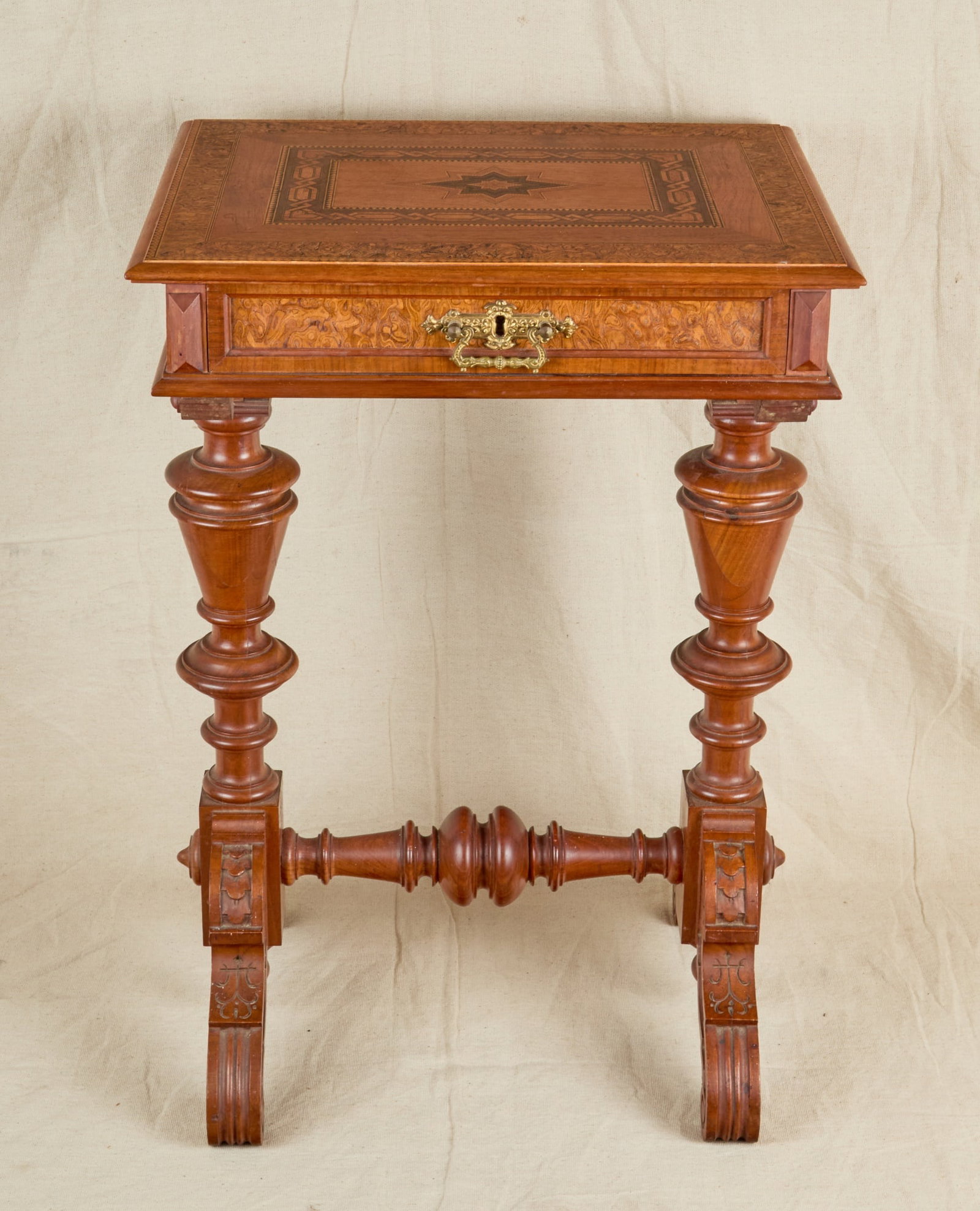 VICTORIAN CARVED & INLAID WALNUT SEWING TABLE: Lift top with beautiful marquetry inlay and burl veneer opens to reveal a slide out sewing drawer fitted with several compartments, heavily carved & turned stretcher base. 28 1/2 x 19 3/4 x 15 3/4 inc