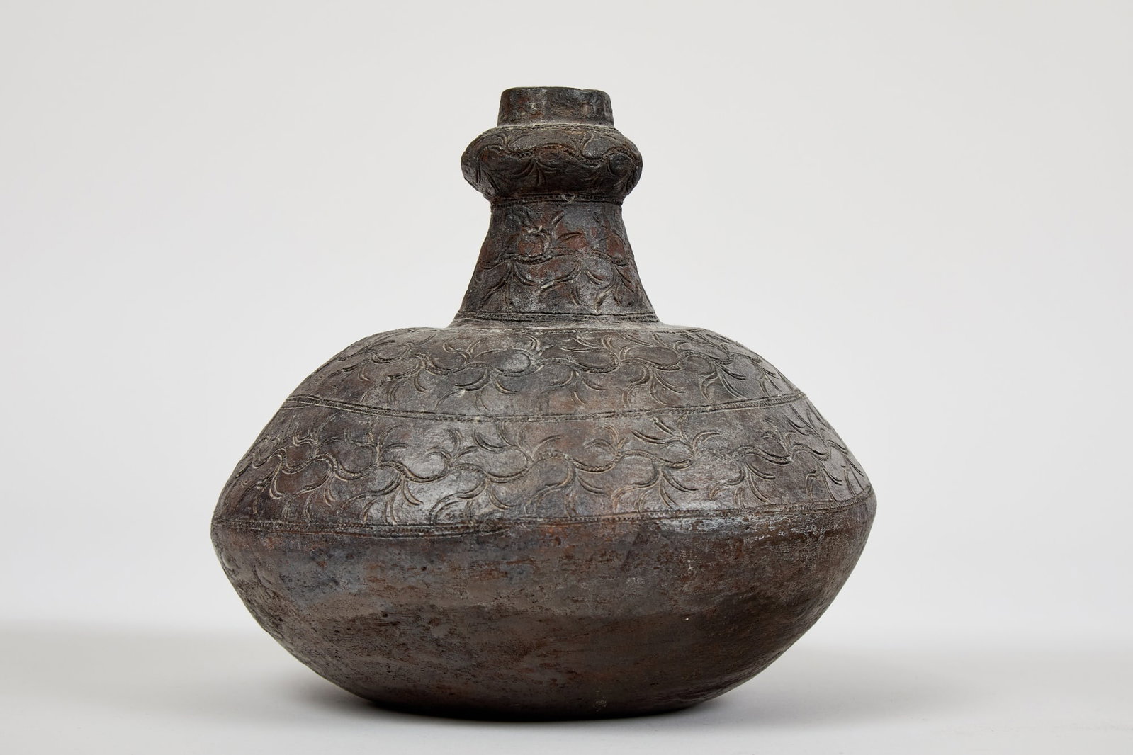 ANTIQUE SOUTHEAST ASIAN TERRA COTTA VASE: With incised floral design and rich dark patina. 10 x 9 inches.