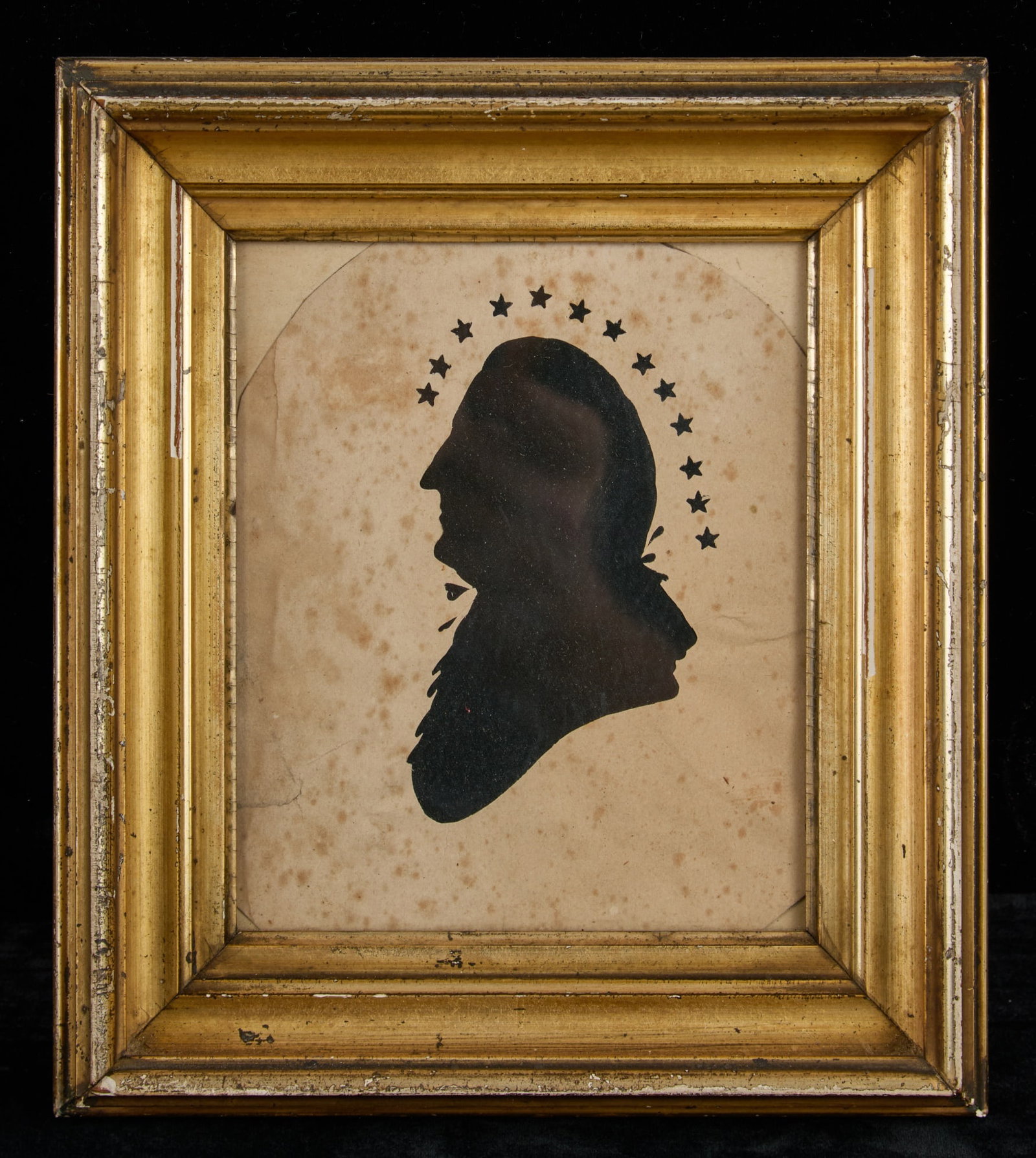 (18th/19th c) SILHOUETTE of GEO. WASHINGTON: (18th/19th c) hollow cut silhouette portrait of George Washington with (13) stars above head, framed with newer black fabric backing in a lemon gold frame. 8 1/2 x 7 1/2 inches overall.