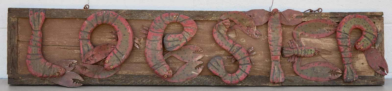 FOLK ART CARVED WOOD & SHEET METAL LOBSTER SIGN: A fabulous folk art "Lobster" sign with each letter composed of a carved & painted wooden and sheet metal lobster. 11 1/2 x 57 inches.