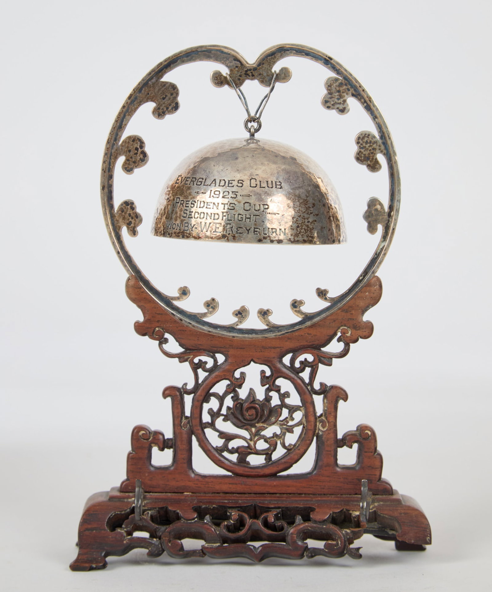 1925 EVERGLADES CLUB PRESIDENT'S STERLING CUP: Palm Beach Florida. Chinese hammered sterling bell and harp mounted to a carved teakwood stand. 7 1/2 x 5 x 1 1/2 inches. 3.6 troy ounces (silver only). N.B. The Everglades Club officially opened in J