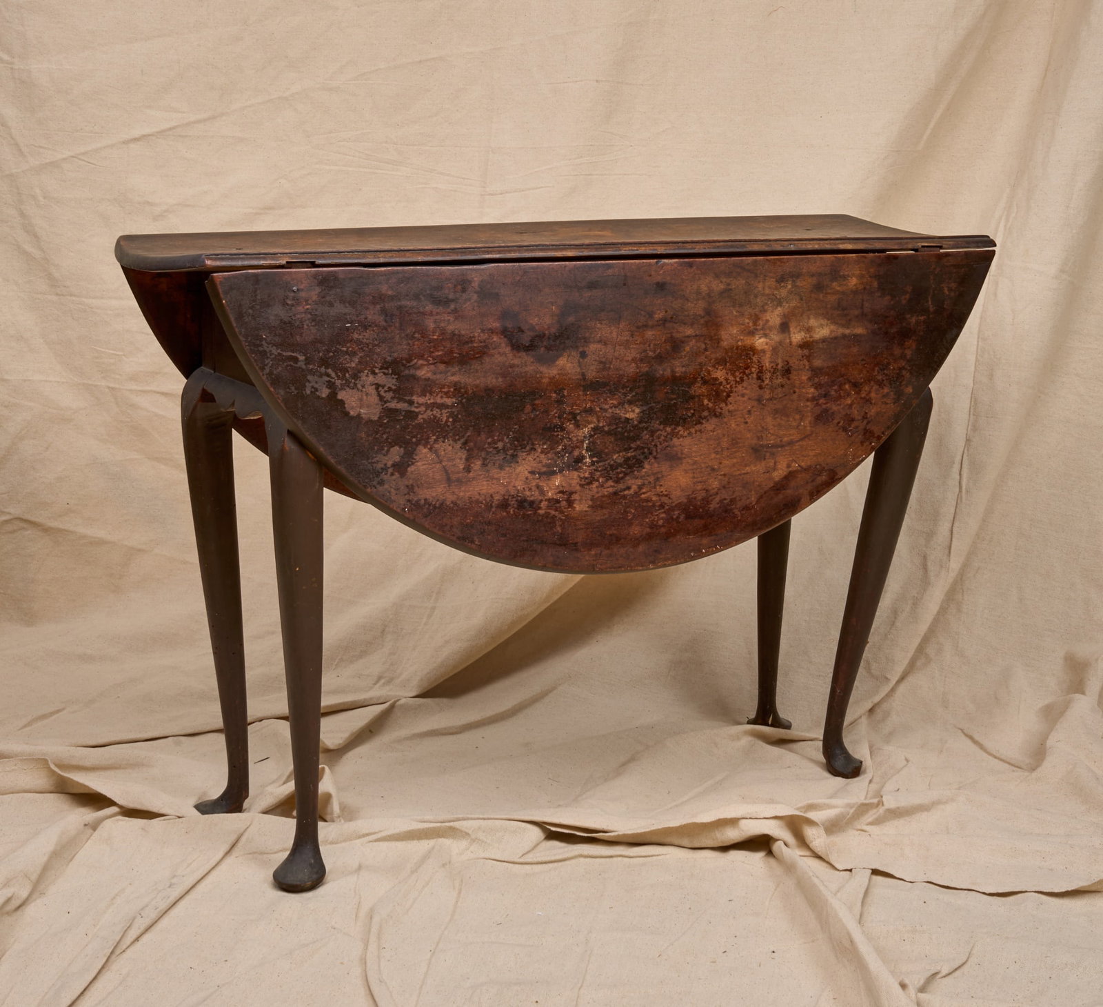 (18th c) QUEEN ANNE MAHOGANY DROP LEAF TABLE: Drop leaves are supported by fly legs that open to a round top over a shaped apron. Customary tapered Queen Anne legs are raised on pad feet. 27 x 41 x 13 1/2 inches (not including 14 inch drop leaves