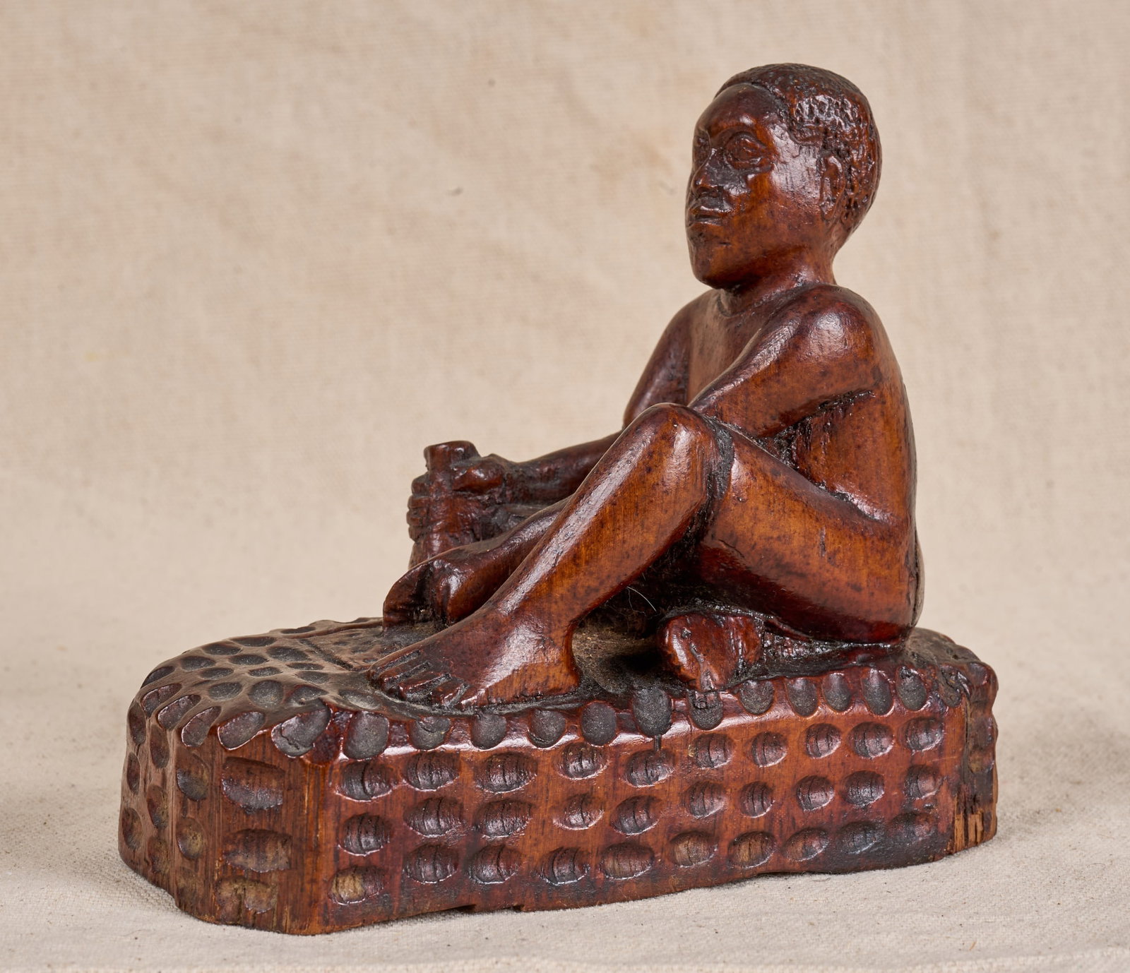 SIGNED AFRICAN-AMERICAN FOLK ART CARVING: African-American folk art carving of a seated man playing a game, signed under base Gabriik? 5 1/2 x 3 x 7 inches.