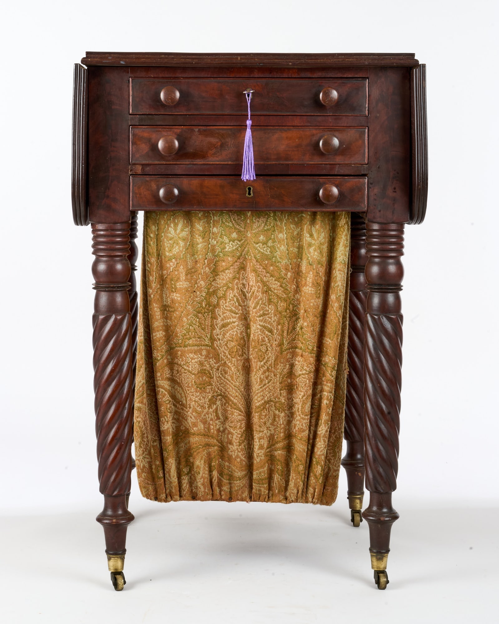(19th c) BOSTON MAHOGANY DUAL WORK STAND: Drop leaf top with reeded edge, (3) cockbeaded drawers - upper containing a writing desk, middle with sewing tray, and bottom with nice sewing bag, barley twist legs on brass casters, mahogany seconda