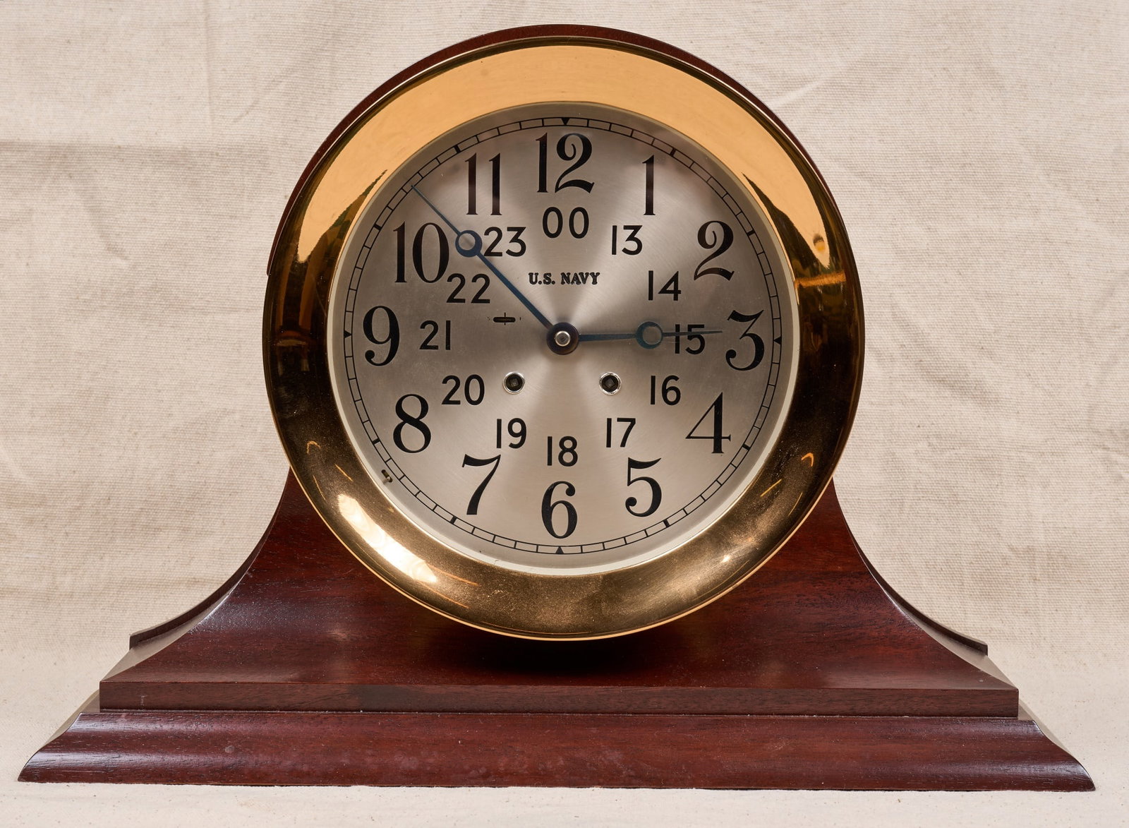 PROTOTYPE US NAVY CHELSEA (24) HR SHIPS BELL CLOCK: CLOCK Unmarked prototype example of ships bell clock commissioned by U.S. Navy in 1948. 10 inch brass case, 7 3/4 inch engraved silver dial with US Navy mark & Breguet hands. On a custom wooden base. 