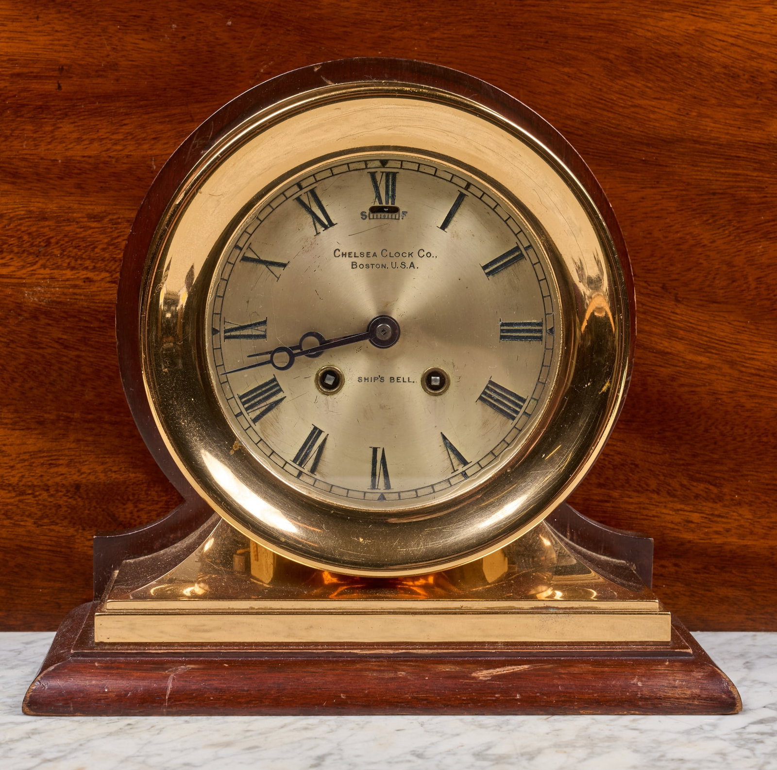 1905 CHELSEA SHIPS BELL MANTEL CLOCK: 7 1/4 inch brass case on removable brass & wooden base, 5 1/4 inches engraved silver dial with Breguet hands. Serial no. 17214. Inscription verso "Manufactured 12-12-05". 9 1/2 x 10 1/4 x 5 1/4 inches