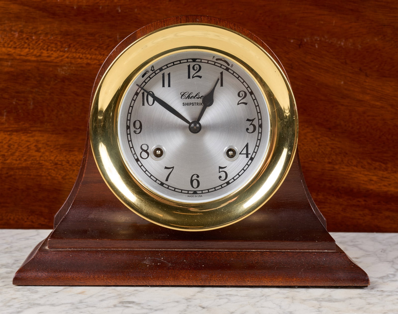 CHELSEA SHIPSTRIKE MANTEL CLOCK: 5 1/2 inch brass case on wooden base, 4 inch silver dial, ships bell chime. 7 1/4 x 9 1/2 x 4 inches.