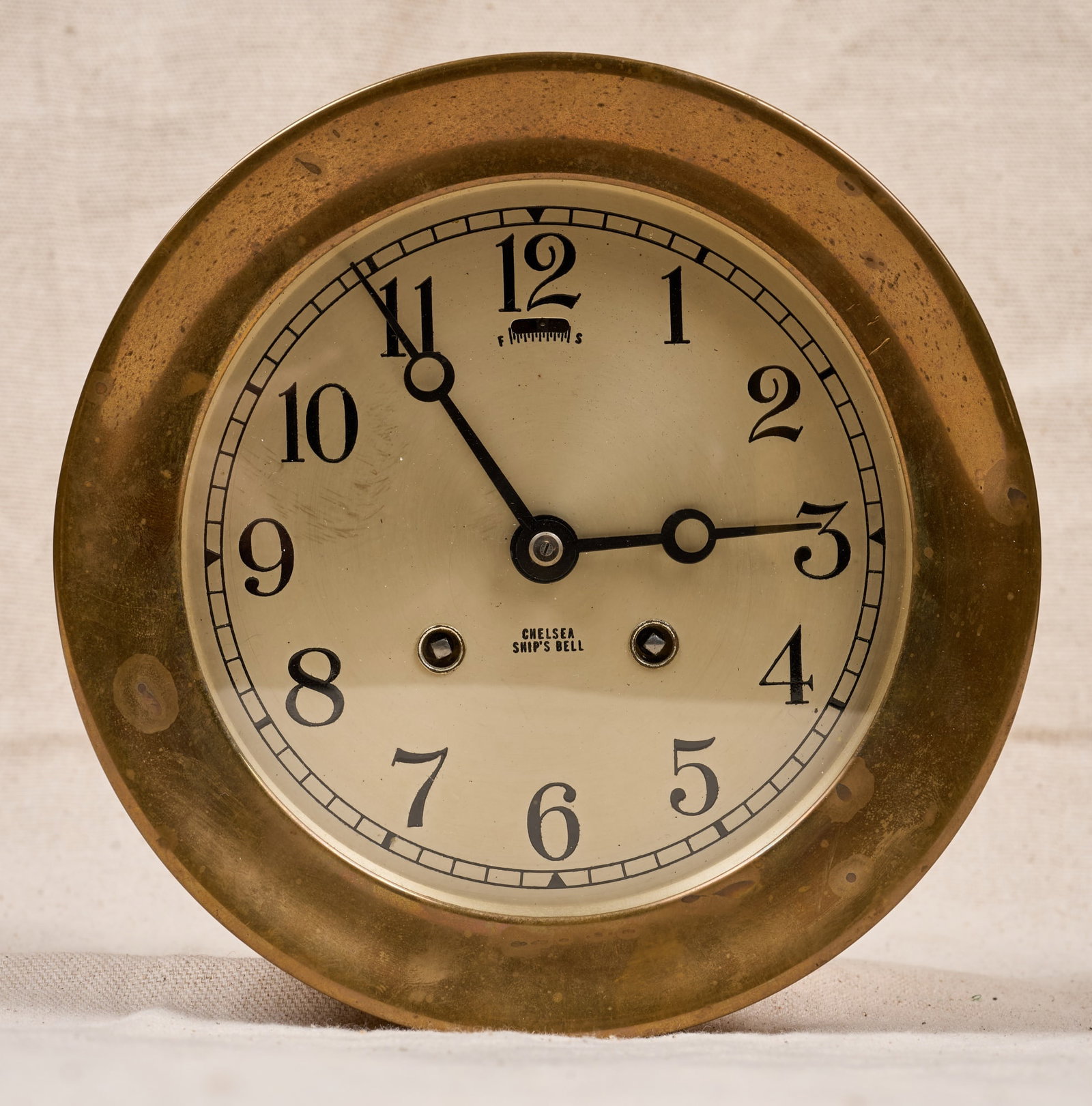 7 1/4 INCH CHELSEA CLOCK CO. BRASS CLOCK: 7 1/4 inch brass case, 5 inch engraved silver dial with Breguet hands. Serial no. 101261 and 526899. 7 1/4 x 3 1/2 inches.