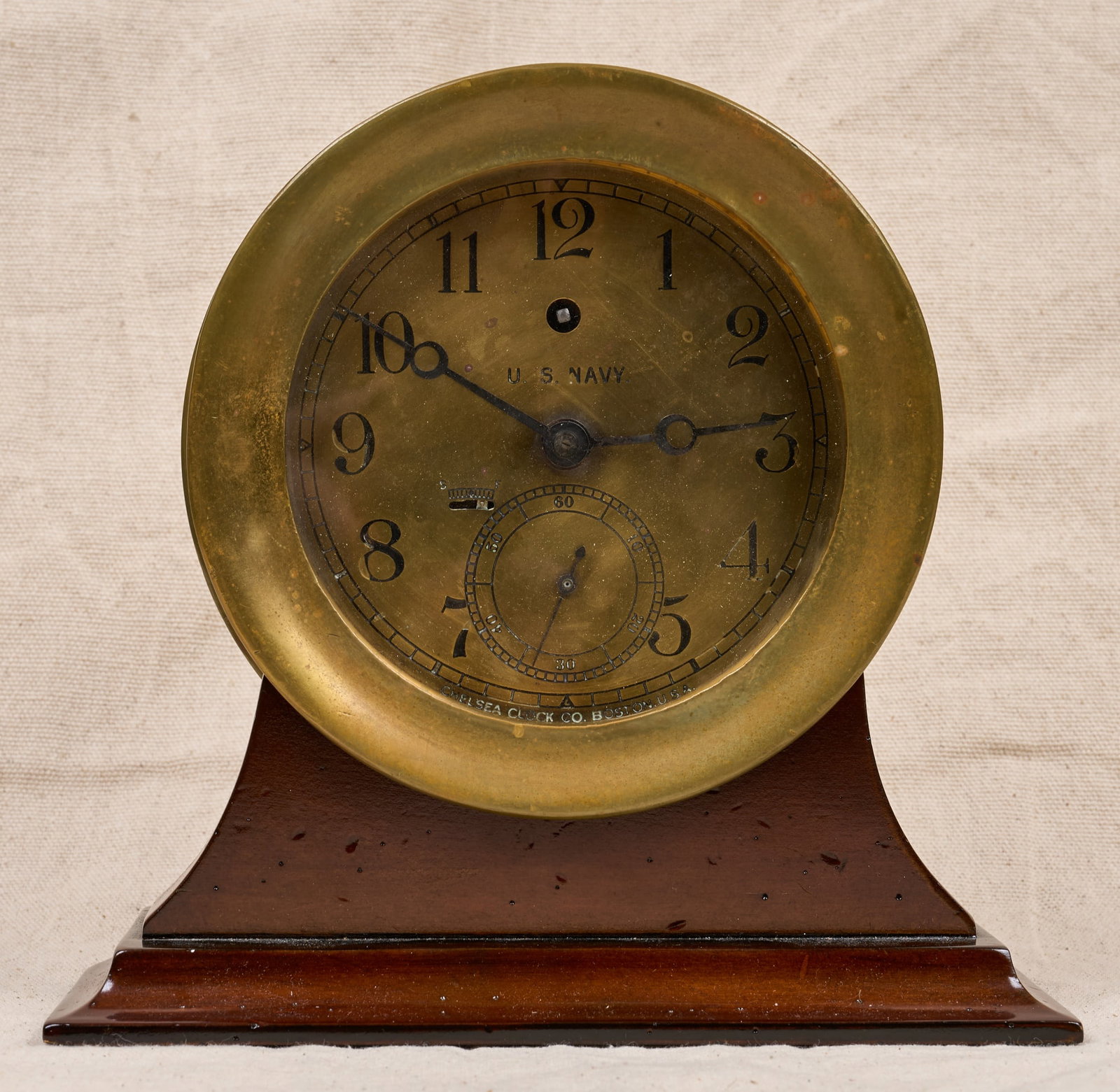 WWI US NAVY CHELSEA CLOCK CO BRASS CLOCK: 7 1/4 inch brass case ,5 1/4 inch engraved brass dial with US Navy mark & Breguet hands. Serial no. 120817, circa 1915-19. With custom wooden base. 9 1/2 x 9 1/2 x 4 inches.