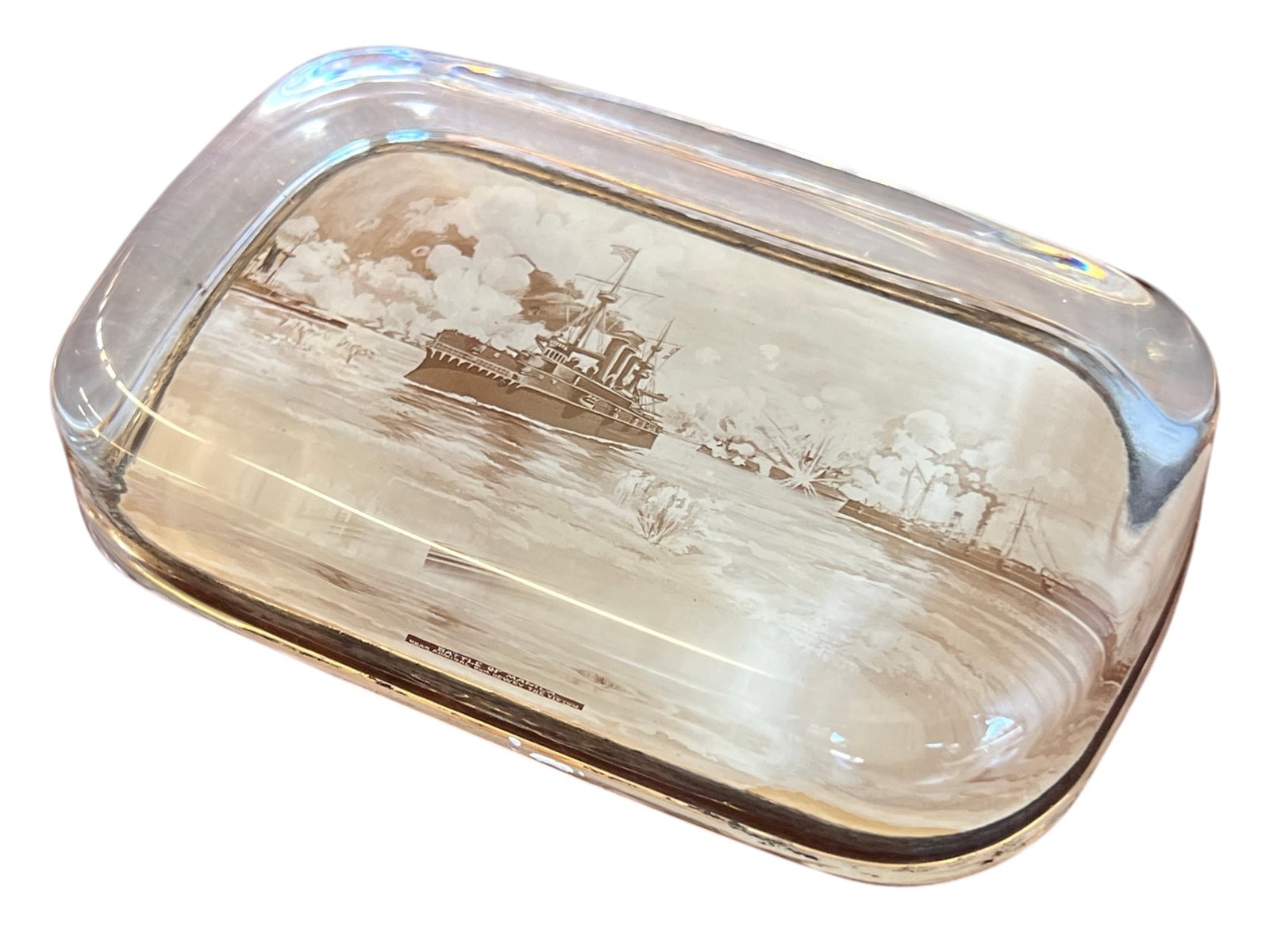 BATTLE OF MANILA/ADMIRAL DEWEY PAPERWEIGHT: Glass paperweight with lithograph scene of "Battle of Manila Rear Admiral Geo. Dewey the Victor". 2 1/2 x 4 inches.