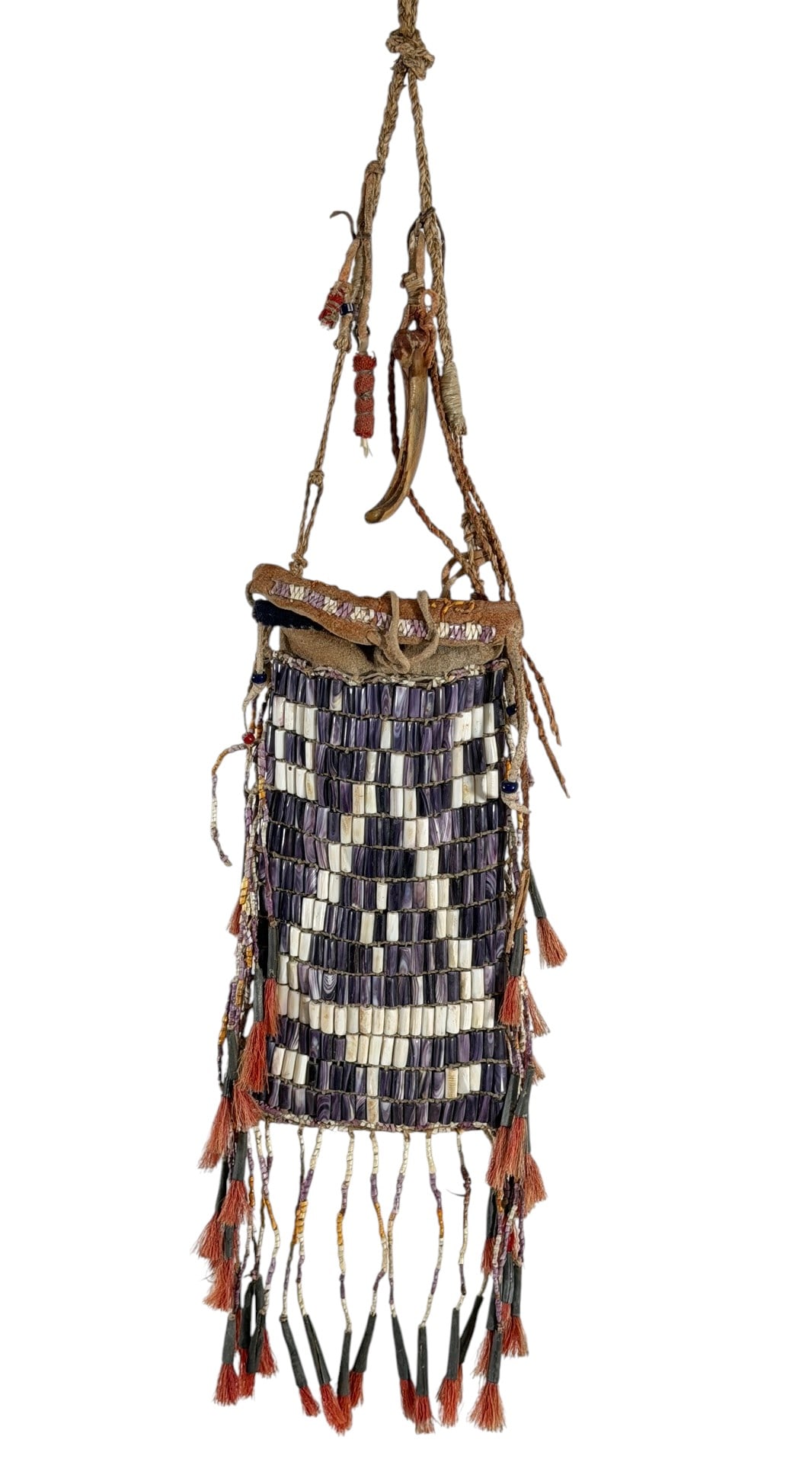 WAMPUM BEADWORK BAG: Native American buckskin bag with Wampum beadwork pine tree, dyed natural hair tassels, other glass beads, bear claw charm. 8 1/4 x 4 1/4 inches excluding handle.
