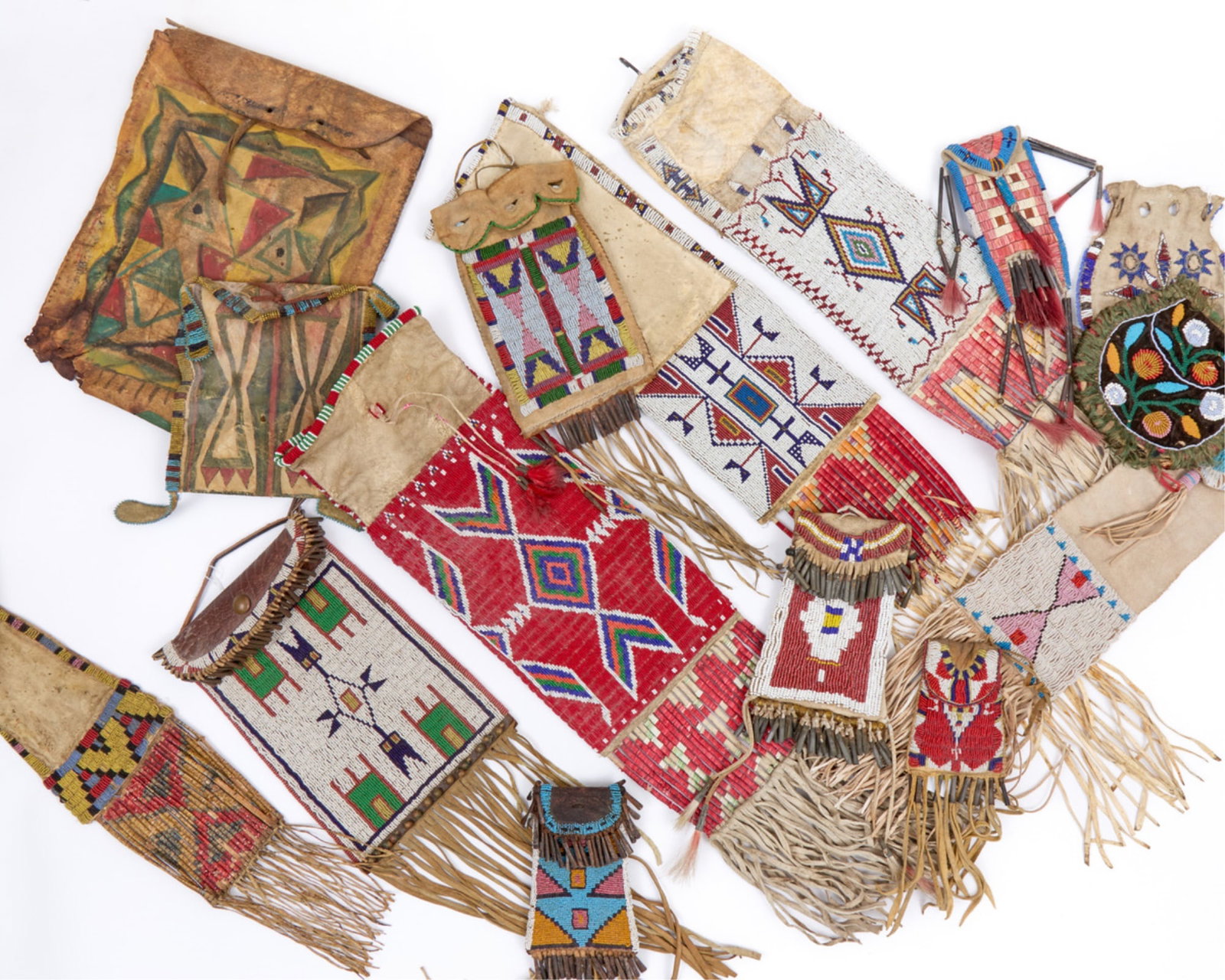 PLAINS INDIANS PIPE BAG with EXTENSIVE BEADWORK: Rawhide pipe bag with extensive geometric polychrome beadwork to both sides, quill wrapped tassels. 27 x 7 1/2 inches.