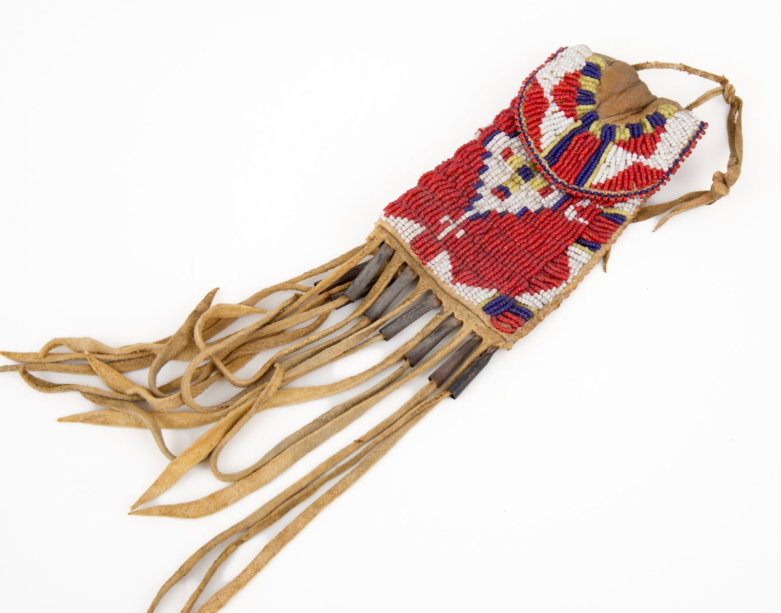 SMALL PLAINS INDIANS BEADWORK PIPE BAG: Plains Indians buckskin pipe bagh with extensive geometric polychrome beadwork & tin cone tassels. 5 x 3 3/4 inches excluding fringe.