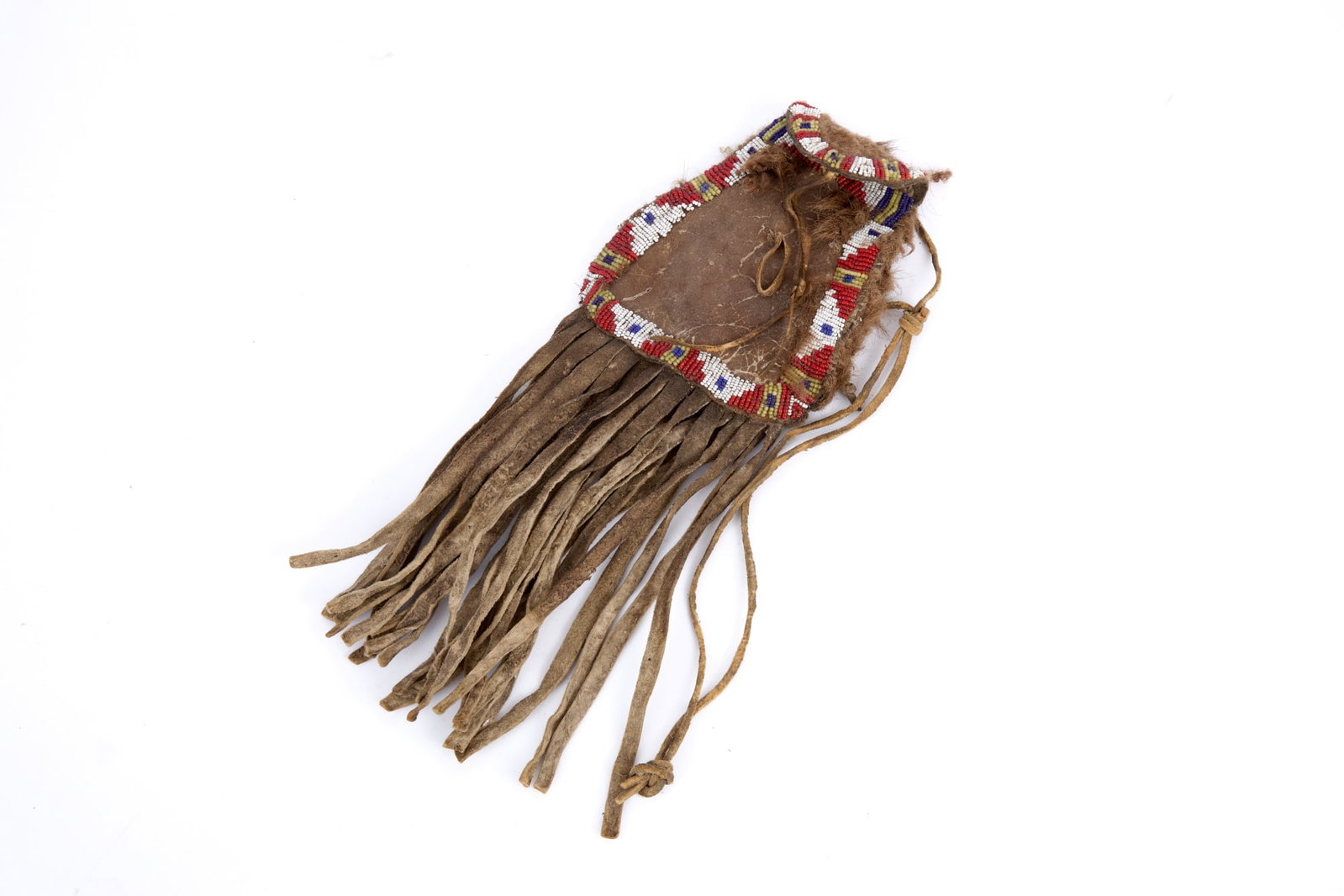 BUFFALO HAIR & BEADWORK STRIKE A LIGHT BAG: Native American buckskin strike a light bag with geometric polychrome beadwork border & buffalo hair remnants. 12 x 4 1/2 inches.