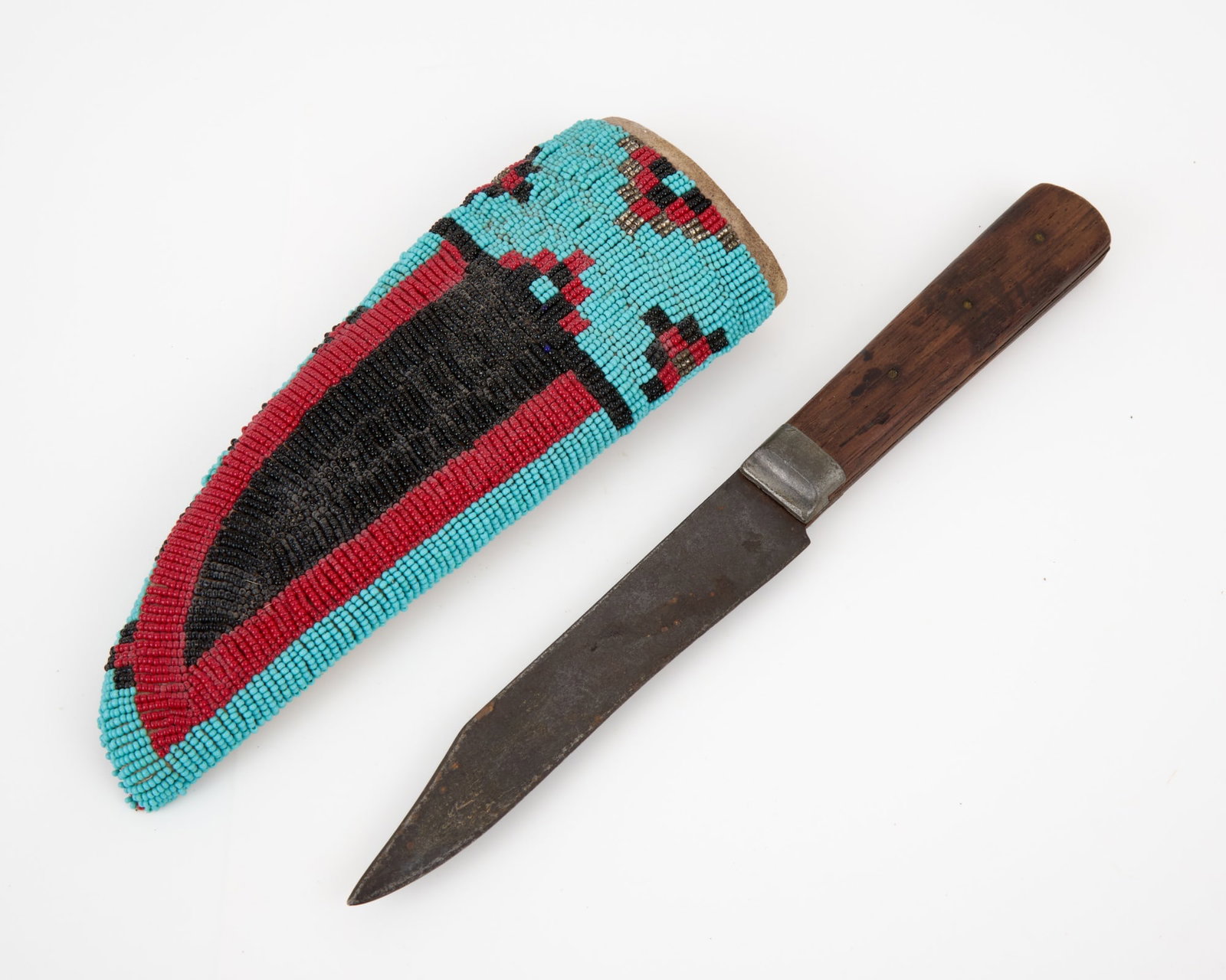 PLAINS INDIANS KNIFE & SHEATH w METALLIC BEADWORK: Plains Indians trade knife & rawhide sheath with geometric polychrome beadwork including a knife blade & metallic beads. 10 3/4 inches.