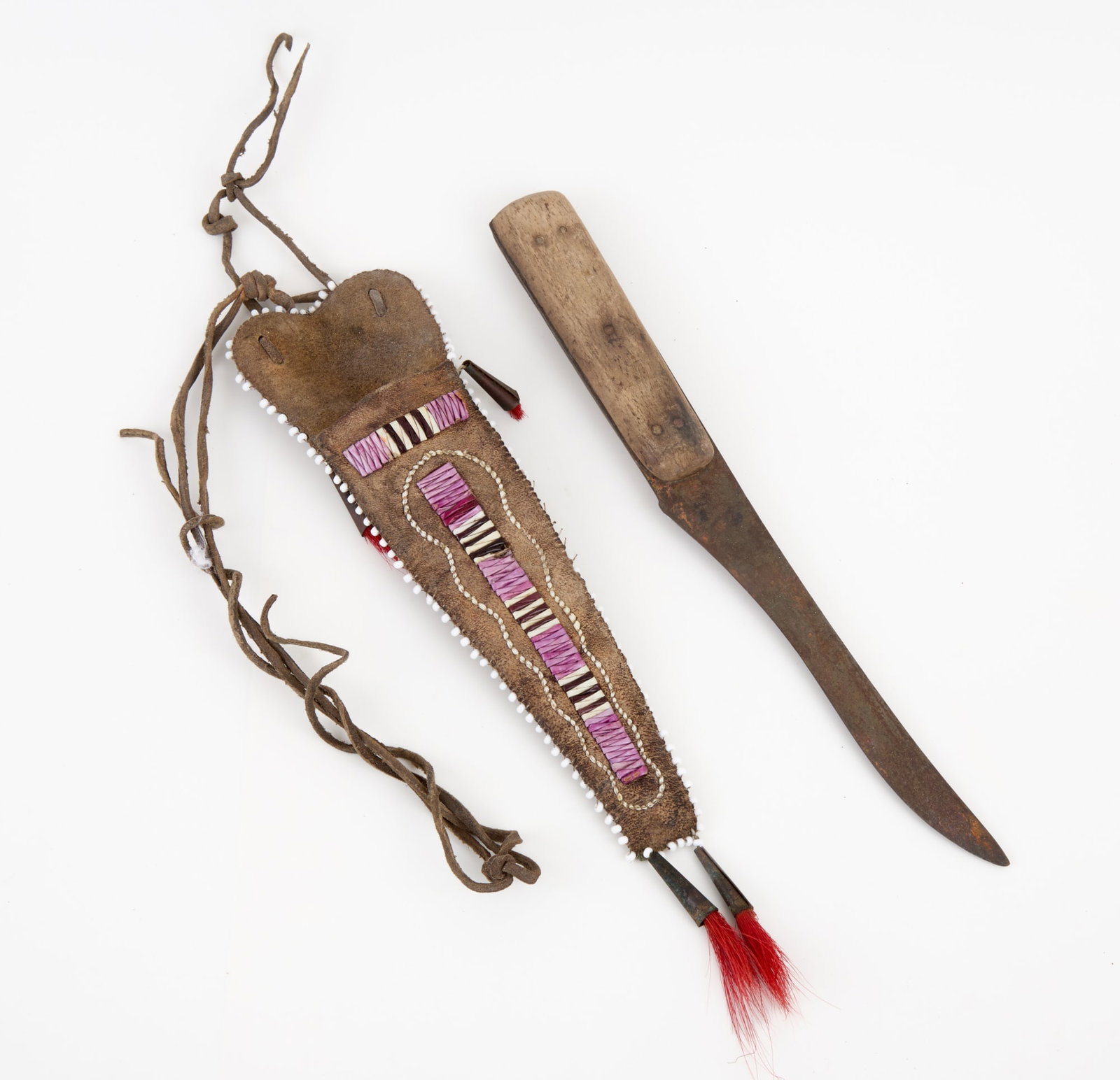 NATIVE AMERICAN KNIFE with QUILL & BEADWORK SHEATH: Rawhide sheath with polychrome quillwork (possibly imitating Wampum), bead fringes, and tin cone tassels with dyed horse hair. 11 1/4 inches.