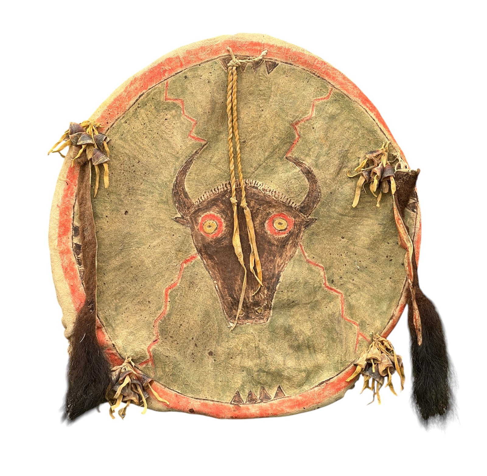 PLAINS INDIANS PAINTED BUCKSKIN BISON SHIELD: Plains Indians painted buckskin shield/drumhead with an angry bison head & lightning strikes on a green field with red border & bear claw marks, bison tail, and bison dewclaw rattles. 20 inches.