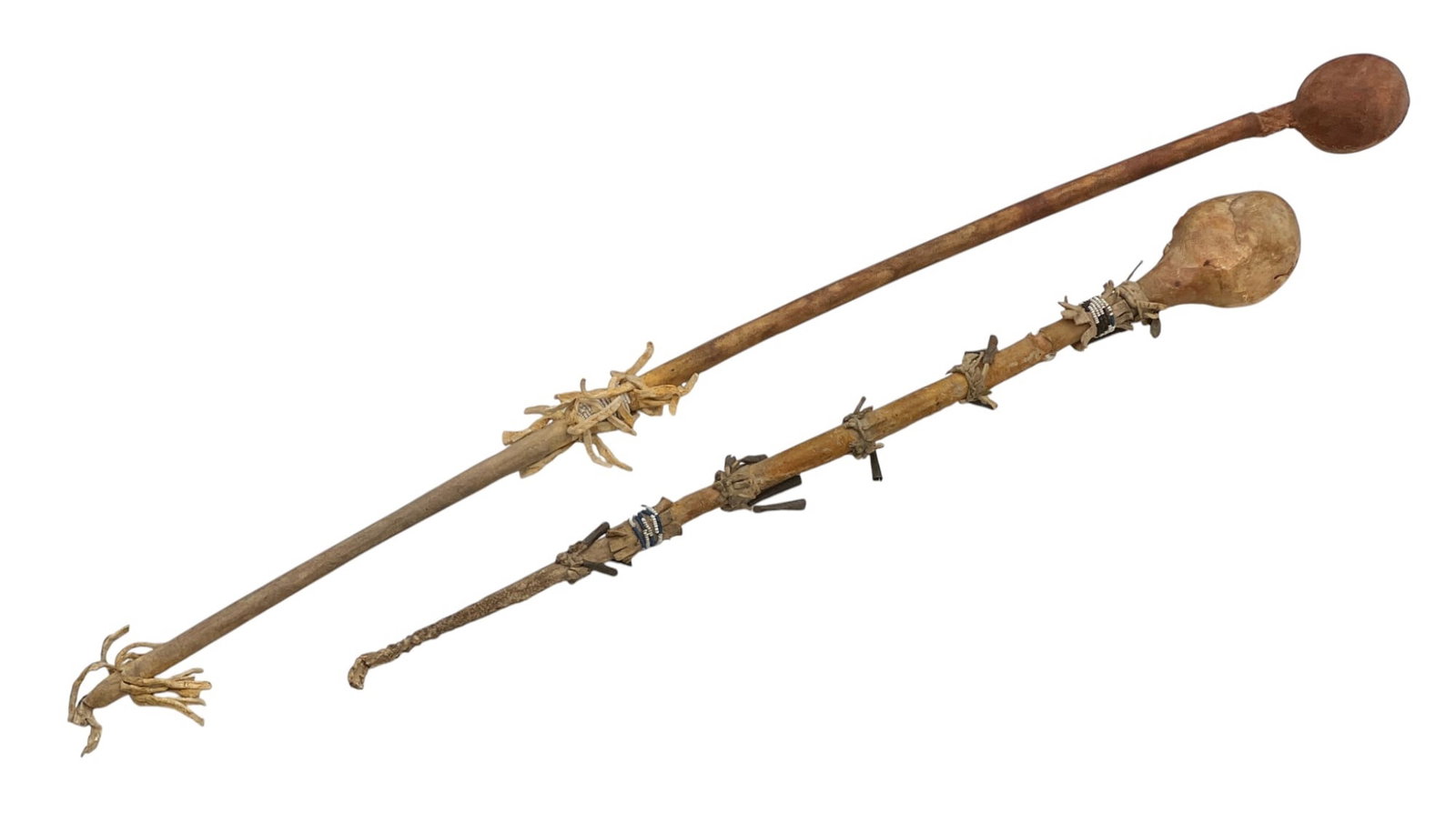 (2) PLAINS INDIANS STONE HEAD WAR CLUBS: Rawhide wrapped wooden handle with stone head sewn into rawhide, tin cone tassels, some polychrome beadwork. 31 inches.