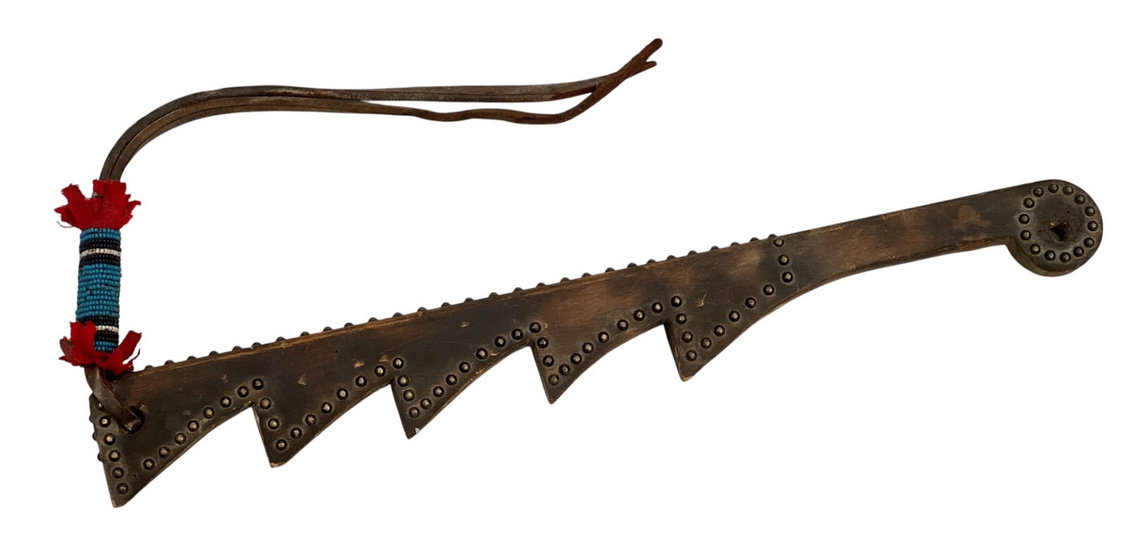 PLAINS INDIANS SAWTOOTH QUIRT: Plains Indians carved wooden sawtooth riding quirt with brass trade tack decoration and leather whips with polychrome beadwork & red wool trade cloth charm. 21 inches; 38 inches overall.