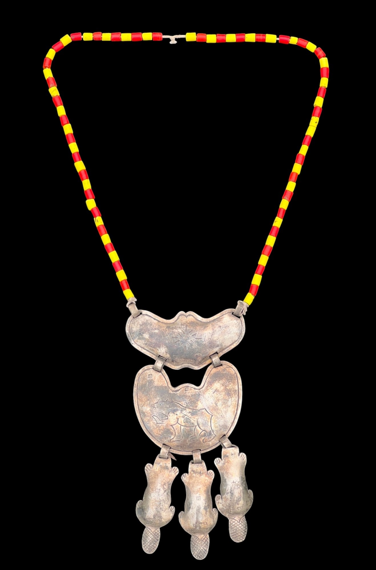 HUDSON BAY STERLING & TRADE BEAD NECKLACE: Hudson Bay necklace with (2) sterling gorgets engraved with northern star and bear, & (3) beaver drops (various hallmarks: HB, Montreal, WS) on a red & yellow trade bead necklace. 25 inches.