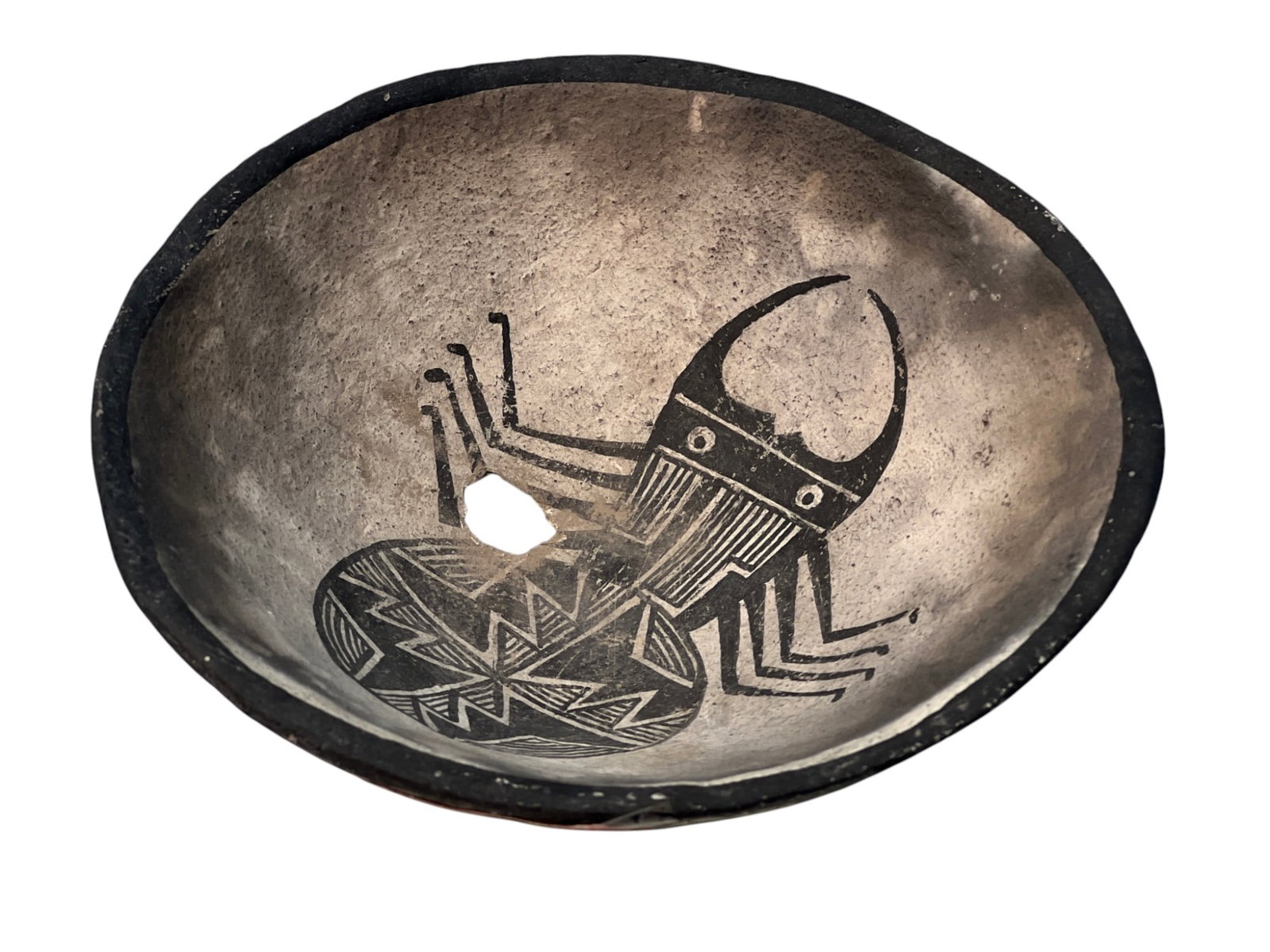 MIMBRES POTTERY BOWL: Mimbres pottery bowl with geometric painted spider. 2 x 6 inches. N.B. Hole in center of basin is characteristic of Mimbres pottery bowls and associated with a funerary ritual.