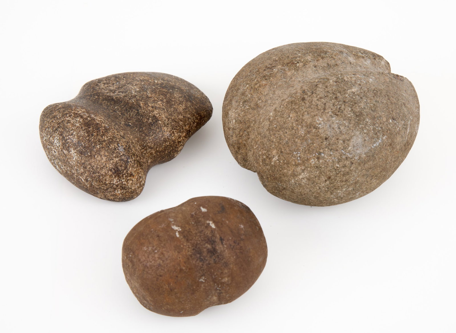 (3) NATIVE AMERICAN STONE TOOL ARTIFACTS: (1) ax head/celt form & (1) ball club form. With grooves for attachment. 4 x 4 inches.