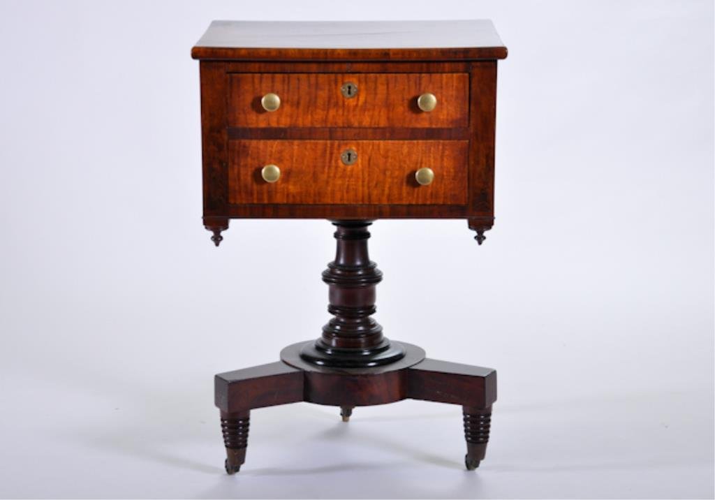 (19th c.) Sheraton Mahogany Sewing Stand: Two-drawer stand with tiger maple fronts on turned pedestal with three turned legs. 32 x 18 x 21 1/4 inches. Condition: Minute shrinkage crack to top