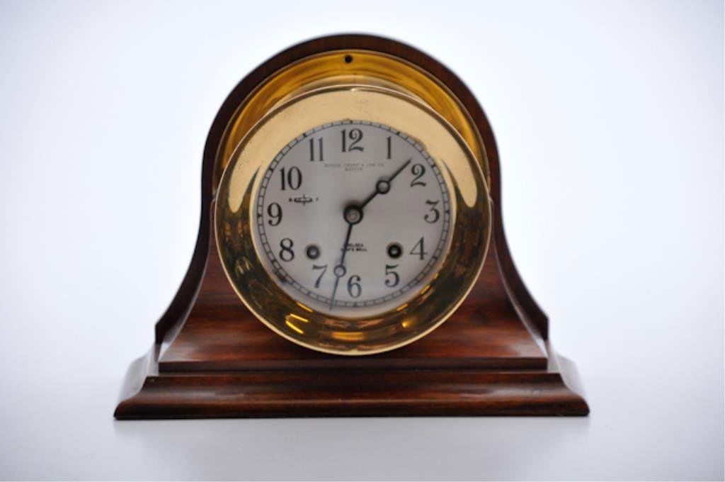 Chelsea Ship's Bell Clock: Brass chiming shelf clock with 4 inch face fitted in a 9 inch mahogany stand. Retailed by Shreve Crump an Low Co. Boston Condition: Good