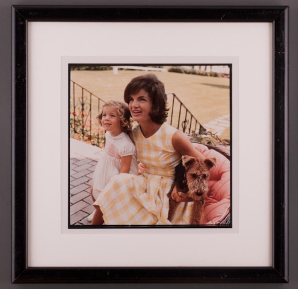 (45) "A Tribute to Jackie" Jacques Lowe: "Jackie, Caroline and dog sitting on wicker chair on porch with backs to stairway" Hyannis Port 1960. 14 x 14 inch photograph, signature not visible. 23 1/2 x 23 1/2 inches framed. (abrasions to frame
