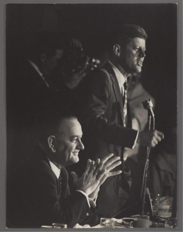 Photograph of John F. Kennedy at the DNC: (1) Large format photograph of John F. Kennedy addressing the crowd at the Democratic National Convention. Lyndon B. Johnson is seated at Kennedy's side, 13 3/4 x 10 1/2 inches, stamped "photo by Bill
