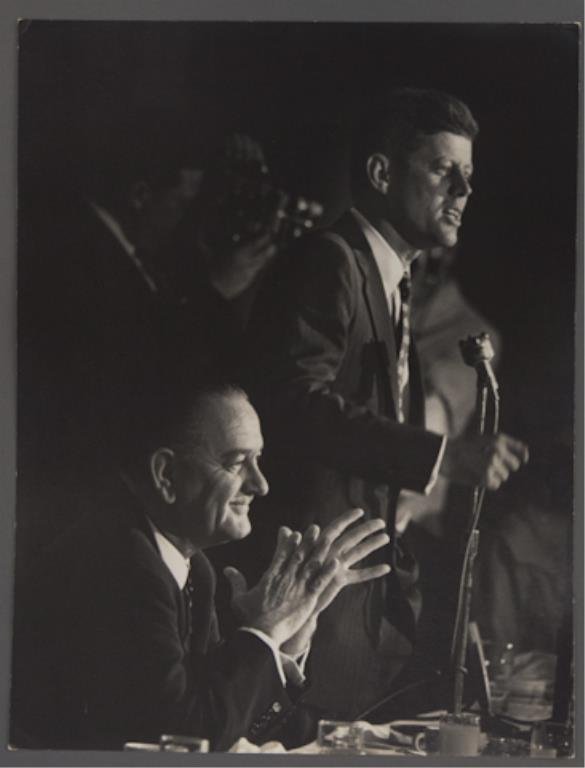 Photograph of John Kennedy at DNC: (1) Large format photograph of John F. Kennedy addressing the crowd at the Democratic National Convention. Lyndon B. Johnson is seated at Kennedy's side, 13 3/4 x 10 1/2 inches, (small bump left upper