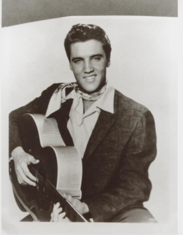 Elvis Presley: (2) 4 x 5 inch negatives (identical) of Elvis Presley, together with (1) 4 x 6 inch photograph reprint. Elvis is posed seated with a guitar on his knee.