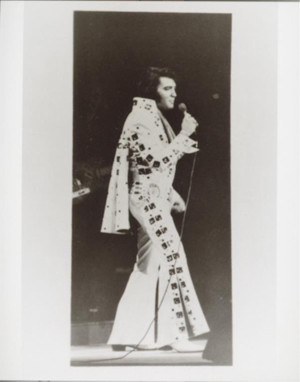 Elvis Presley: (1) 4 x 5 negative of Elvis Presley, together with (1) 4 x 6 inch photograph reprint. A full-body, side view of Elvis on stage holding a microphone.