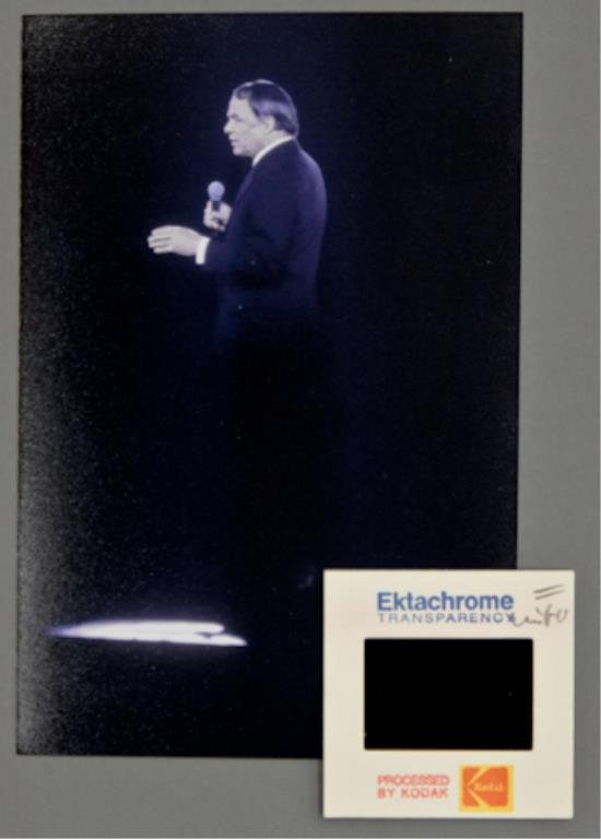 Frank Sinatra: (1) 35mm color transparency of Frank Sinatra marked "Sinatra Waldorf 1979", together with (1) 4 x 6 inch photograph reprint. Side view of Sinatra on stage with microphone in hand. Waldorf Astoria, New