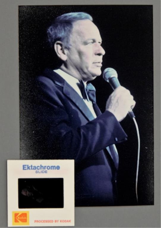 Frank Sinatra: (1) 35mm color transparency of Frank Sinatra, together with (1) 4 x 6 inch photograph reprint. Waist-high shot of Sinatra holding a microphone. From the "Main Event" tour 1974.