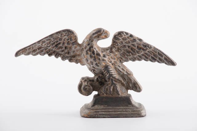 Cast Iron Eagle: Painted cast iron eagle, old silver over gold paint. 6" high, 10 1/2" wide. Condition: Wear.