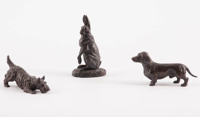 Three Bronze Animal Figures: Miniature bronze figures of Dachshund dog, a Scottish Terrier dog, and a rabbit. The rabbit is 3 3/4" tall and is signed DUBUCAND. Condition: Good.