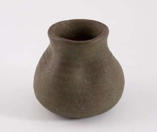 Merrimac Pottery Vase: Merrimac Ceramic Company of Newburyport,MA, c.1902 Interesting turned and pinched redware vase with green glaze. Signed with incised stamped sturgeon and the original paper label. 4 inches. Condition: